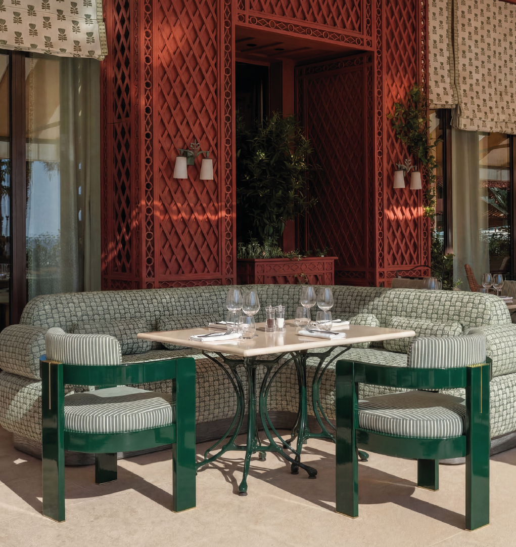 Luxury outdoor dining setup with green chairs and upholstered banquette seating
