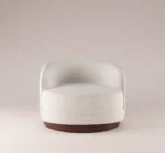 Mahler Armchair in a modern, minimalist style with soft texture and a wooden base, designed for contemporary living spaces.