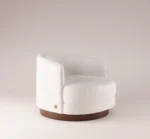 Mahler Armchair in a modern, minimalist style with soft texture and a wooden base, designed for contemporary living spaces.