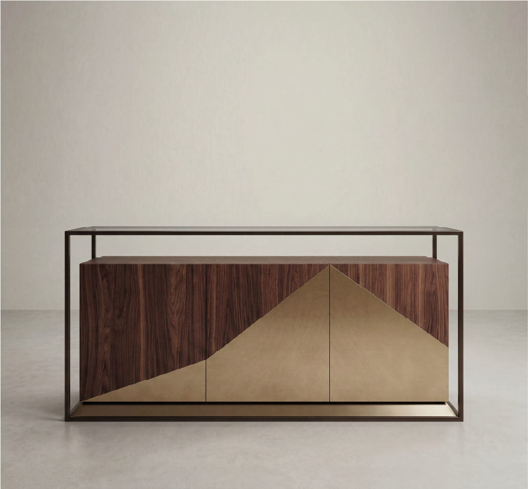 This image features the Ilyich Desk styled within a warm and sophisticated interior, framed by rich wood paneling that enhances its material depth. Crafted in a dark-toned wood, the desk showcases a bold architectural silhouette, complemented by subtle brass accents that highlight its structure and edges. A central drawer and integrated side cabinet provide functional storage while maintaining a clean, balanced design. Paired with a textured upholstered chair and curated decorative elements, the desk becomes the focal point of the workspace. The interplay of natural materials, warm lighting, and geometric forms creates an atmosphere of understated luxury, making the Ilyich Desk a statement piece for refined and contemporary interiors.