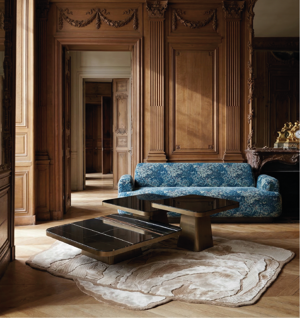 Monteverdi modular marble center table in classic wood-paneled living room with blue upholstered sofa. Title