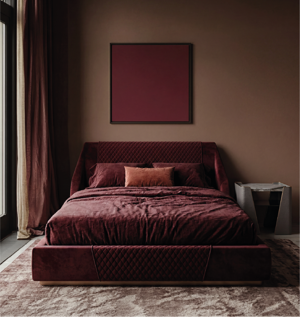 Purcell upholstered bed in deep burgundy velvet with quilted headboard in a modern bedroom with warm tones and soft lighting.