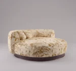 Hedy chaise lounge in cream and gold botanical upholstery with rounded silhouette and dark walnut wood base